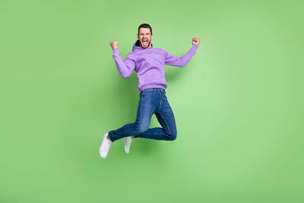 Foto de tamaño completo de hombre joven feliz sonrisa positiva salto regocijo victoria éxito aislado sobre fondo de color verde —  Fotos de Stock