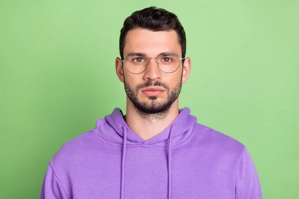 Foto de hombre guapo joven serias gafas de desgaste de jersey confiado aislado sobre fondo de color verde —  Fotos de Stock