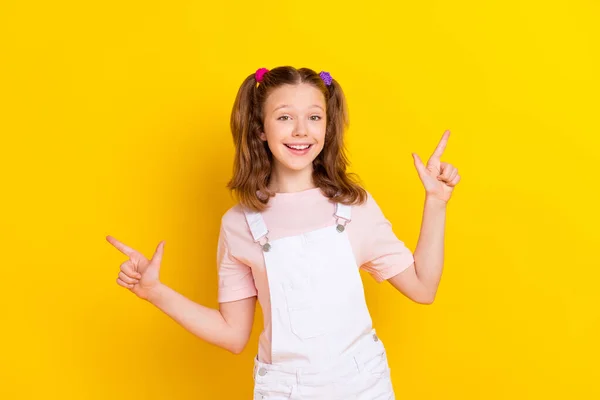 Fényképezés portré iskoláslány farokkal mutató ujjak üres tér elszigetelt élénk sárga színű háttér — Stock Fotó