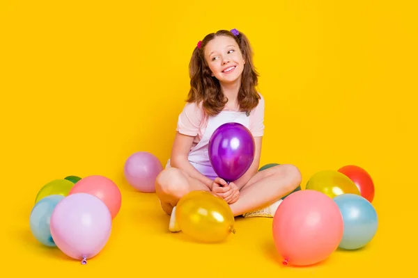 Ganzkörpergröße Foto Schulmädchen auf einer Party mit Luftballons suchen Kopierraum verträumt isoliert lebendige gelbe Farbe Hintergrund — Stockfoto