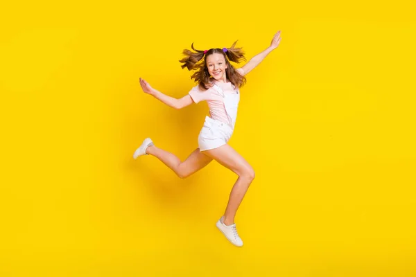 Longitud completa vista del tamaño del cuerpo de la atractiva chica alegre saltando divertirse corriendo aislado sobre fondo de color amarillo brillante —  Fotos de Stock