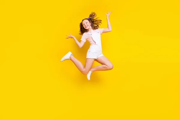 Full längd kroppsstorlek bild av attraktiv glad flicka hoppning lura vila semester isolerad över ljust gul färg bakgrund — Stockfoto
