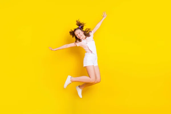밝은 노란색 배경 위로 분리 된 유쾌 한 기분을 즐기고 있는 매력적 인 쾌활 한 소녀의 전체 몸길이 사진 — 스톡 사진