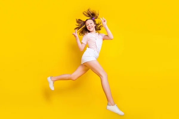 Πλήρες μήκος σώματος μέγεθος άποψη του ελκυστικού trendy χαρούμενο κορίτσι άλμα τρέξιμο δείχνει v-σημάδι απομονώνονται σε φωτεινό κίτρινο χρώμα φόντο — Φωτογραφία Αρχείου