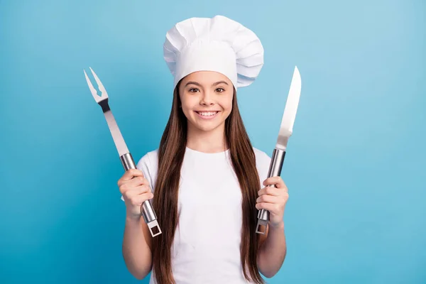 Φωτογραφία από χαρούμενα θετικά χαρούμενο κοριτσάκι χαμόγελο καλή διάθεση κρατήσει μαχαίρι πιρούνι γεύμα απομονωμένο σε μπλε φόντο χρώμα — Φωτογραφία Αρχείου