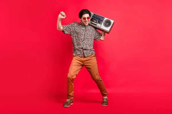 Foto de tamaño completo de buen humor sonriente guapo baile masculino con boombox fin de semana de verano aislado sobre fondo de color rojo — Foto de Stock