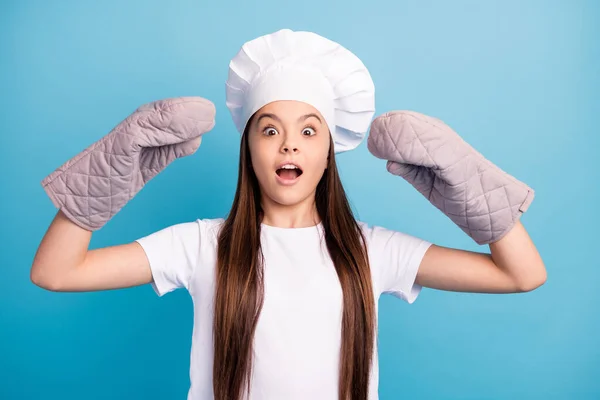Foto di allegro stupito scioccato bambina indossare guanti cappello cucinare cena isolata su sfondo di colore blu pastello — Foto Stock