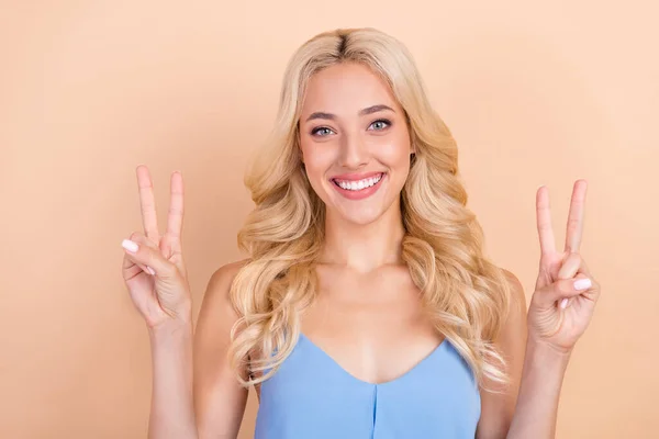 Foto di giovane donna allegra felice sorriso positivo mostrare la pace fresco v-segno isolato su sfondo di colore beige — Foto Stock