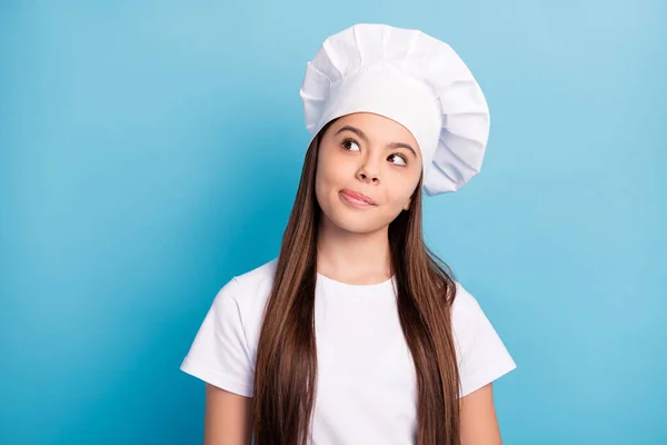 Foto di sognante felice bambina cuoco sguardo vuoto spazio leccare labbra immaginare buon pasto isolato su sfondo di colore blu — Foto Stock