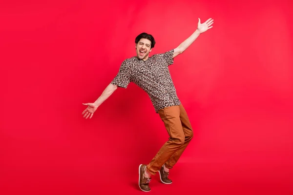 Foto de tamaño completo de buen humor alegre hombre positivo bailando descuidado jugando alrededor aislado sobre fondo de color rojo — Foto de Stock