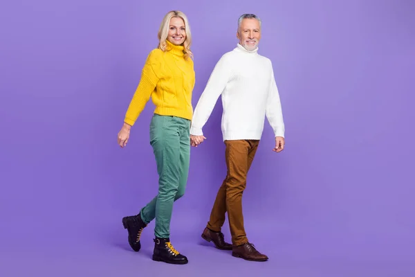 Foto de adorable excitado esposa madura marido usar pullovers de punto sonriente caminar sosteniendo brazos aislado color púrpura fondo — Foto de Stock