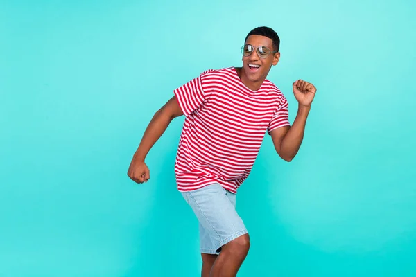 Foto di divertente affascinante giovane uomo indossare a strisce t-shirt sorridente danza isolato colore verde acqua sfondo — Foto Stock