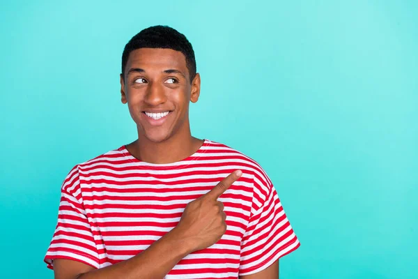 Foto di affascinante grazioso giovane uomo indossare t-shirt a righe sorridente guardando indicando spazio vuoto isolato colore verde acqua sfondo — Foto Stock