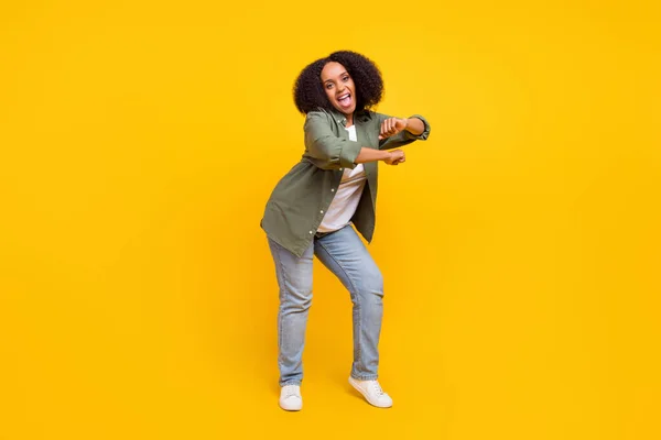 Foto de corpo inteiro de impressionado morena jovem plus size senhora dança desgaste camisa jeans calçado isolado no fundo de cor amarela — Fotografia de Stock