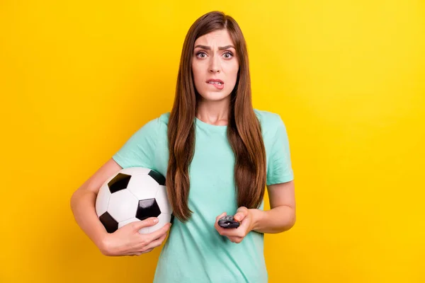 Foto von besorgten brünetten Frisur Millennial Dame halten Ball Switch tv tragen Teal T-Shirt isoliert auf gelbem Hintergrund — Stockfoto