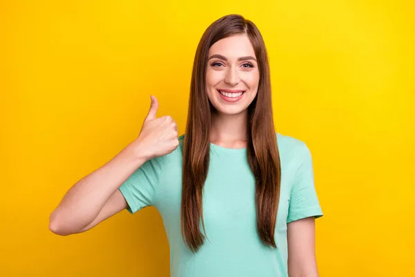 Фото смешной брюнетки прическа Millennial леди большой палец вверх носить бирюзовые футболки изолированы на желтом фоне цвета — стоковое фото