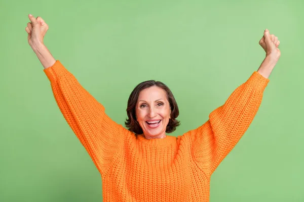 Foto van opgewonden gekke volwassen vrouw vieren overwinning hooray vuisten armen geïsoleerd over groene kleur achtergrond — Stockfoto