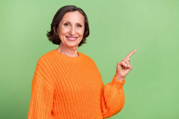 Profilseite Foto von fröhlichen gealterten Dame Promoter zeigen Finger leeren Raum wählen Anzeigen isoliert über grünen Farbhintergrund — Stockfoto