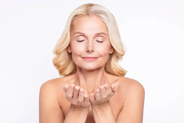 Portret van aantrekkelijke dromerige gezonde grijsharige vrouw wassen heldere huid scrubben geïsoleerd over witte kleur achtergrond — Stockfoto