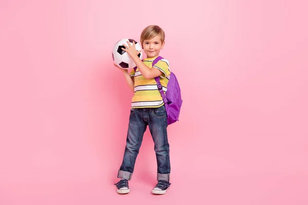 온몸에 보이는 어린 소년 이 핑크 색 배경에 고립된 채 배낭 가방을 들고 축구 경기를 하는 모습 — 스톡 사진