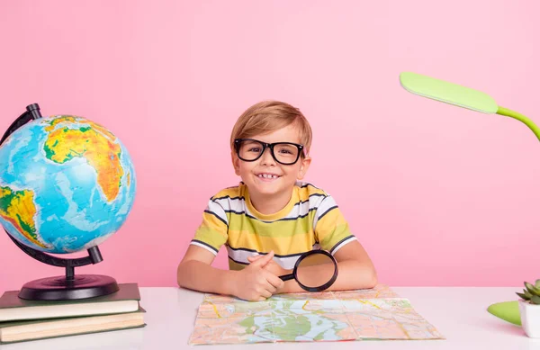 Fotografie malého blondýnka chlapec lekce studie úsměv držet loupe geografie těšit izolované na růžové barevné pozadí — Stock fotografie