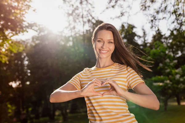 Foto mulher retrato passar tempo livre no parque da cidade verde sorrindo mostrando gesto sinal do coração — Fotografia de Stock