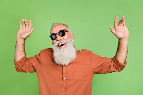 Foto de homem maduro alegre se divertir dança eyewear sentir-jovem roupa casual isolado sobre fundo de cor verde — Fotografia de Stock