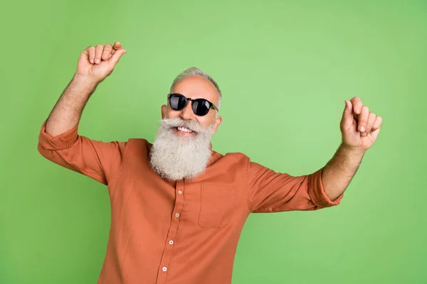 Retrato de atractivo alegre hombre de pelo gris bailando teniendo divertido descanso resort aislado sobre fondo de color verde — Foto de Stock