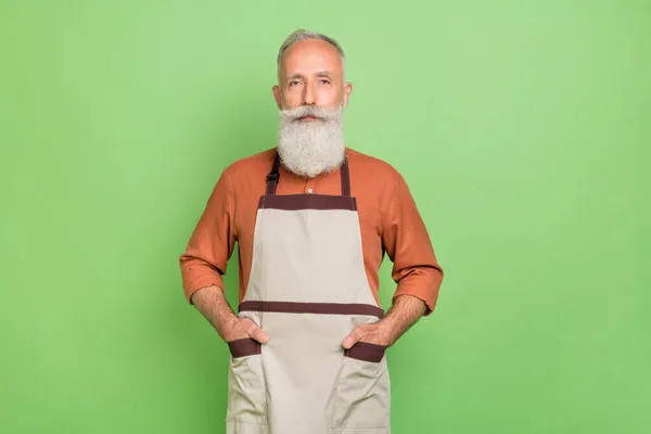 Fénykép az idős üzletember magabiztos kezek zsebében bolt tulajdonos szolgáltatás elszigetelt zöld színű háttér — Stock Fotó