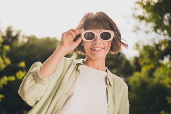Портрет привлекательной веселой беззаботной девушки, одетой в трогательные очки аксессуаров времяпрепровождения отпуск хорошее настроение на свежем воздухе — стоковое фото