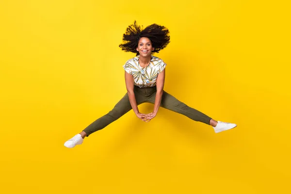 Plná velikost fotografie mladé vzrušené afro dívka bavit skok nahoru energické izolované přes žlutou barvu pozadí — Stock fotografie