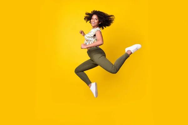 フルサイズプロフィール側の写真の若いですアフロ女の子ジャンプランナー気楽に割引隔離された上の黄色の背景 — ストック写真