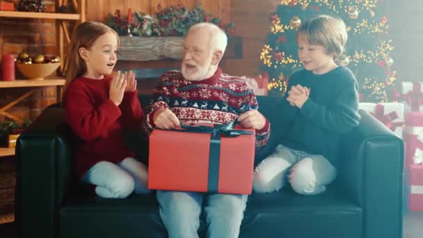Morfar försöka packa upp nuvarande barn plädera upphetsad förväntan — Stockvideo