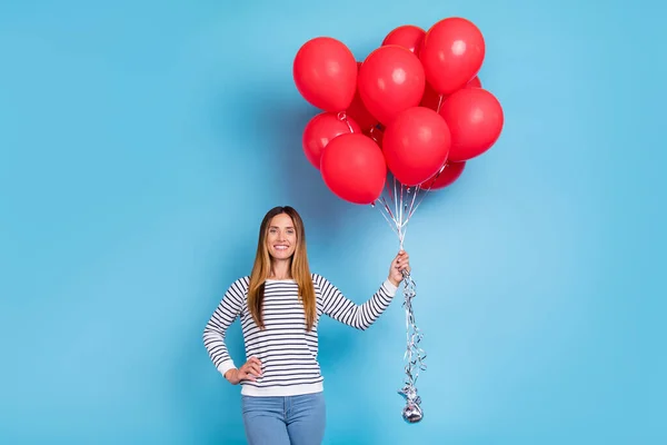 Foto de señora rubia madura optimista sostiene globos usan camisa blanca aislada sobre fondo de color azul — Foto de Stock