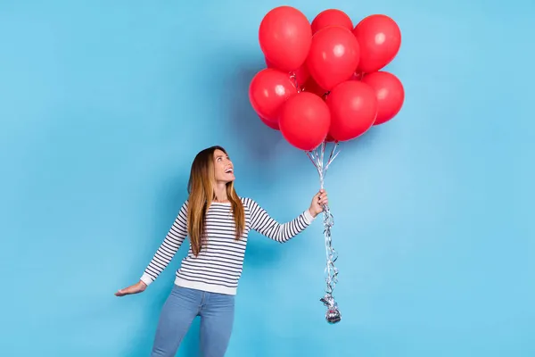 Foto de la joven rubia impresionada señora mira globos usan camisa blanca aislada sobre fondo de color azul — Foto de Stock