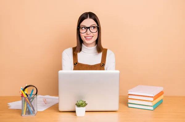 Retrato de atraente mente alegre menina empregado usando laptop criando estratégia isolada sobre fundo de cor bege — Fotografia de Stock