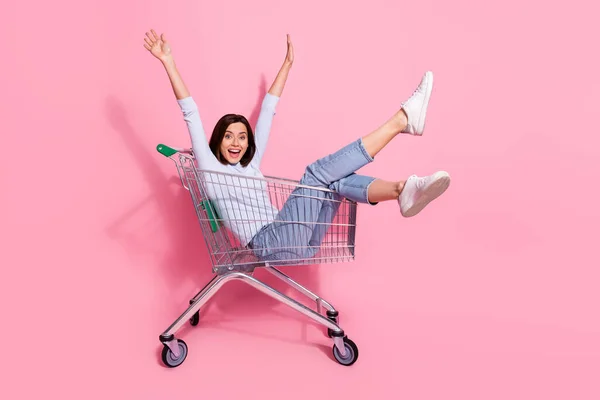 Foto van schattige funky jonge dame gekleed witte trui glimlachen met plezier winkelen trolley geïsoleerde roze kleur achtergrond — Stockfoto