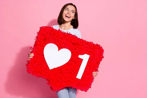 Foto av drömmande charmig ung dam klädd vit jumper håller stora som tecken pinata ser tomt utrymme isolerad rosa färg bakgrund — Stockfoto