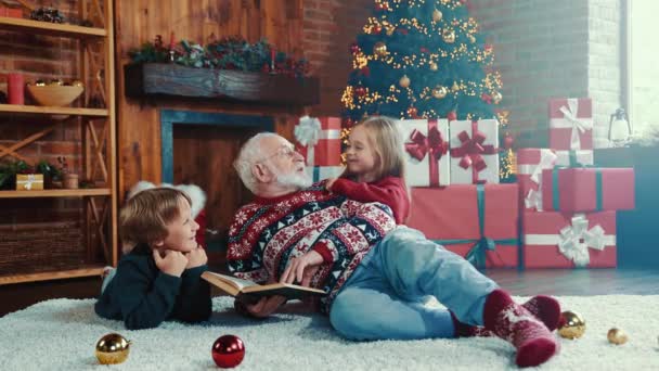 Comfortabele noel avond opa lezen kinderen fee staart x-mas kerstlied — Stockvideo