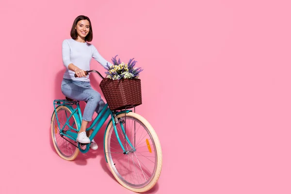 Foto de funky brilhante jovem senhora vestida jumper branco gostando de andar de bicicleta espaço vazio isolado cor rosa fundo — Fotografia de Stock