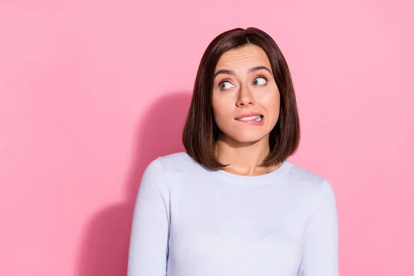 Foto de muito duvidoso jovem senhora vestida branco jumper mordendo lábio olhando espaço vazio isolado cor de fundo rosa — Fotografia de Stock