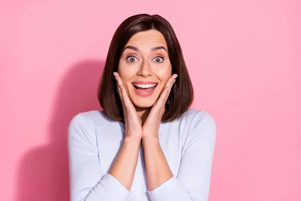 Foto de excitada joven sorprendida vestida de jersey blanco sonriente brazos mejillas a la espera de la venta aislado color rosa fondo — Foto de Stock