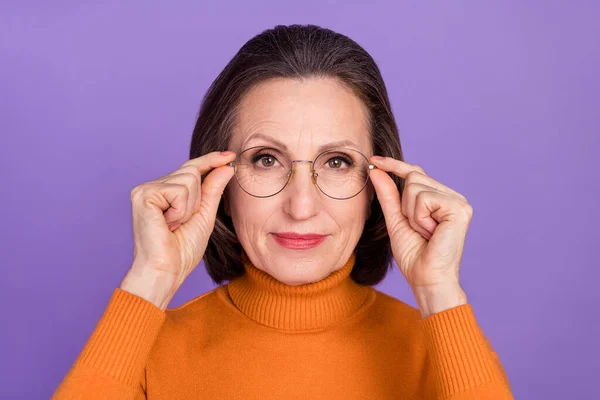 真剣に自信を持って引退した女性の写真は、オレンジプルオーバー腕眼鏡孤立紫色の背景を身に着けている — ストック写真