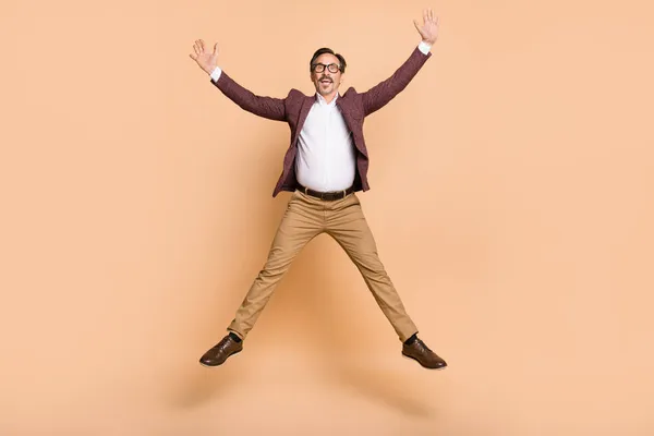 Comprimento total tamanho do corpo vista de homem despreocupado alegre atraente cara pulando se divertindo isolado sobre fundo de cor bege — Fotografia de Stock