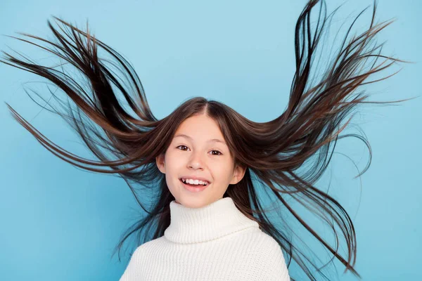 Foto di lucido bella preteen ragazza vestita pullover bianco volare capelli sorridente isolato colore blu sfondo — Foto Stock