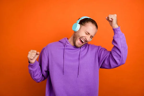 Photo funky millennial brun queue coiffure gars danse écouter musique porter violet sweat à capuche isolé sur fond de couleur orange — Photo