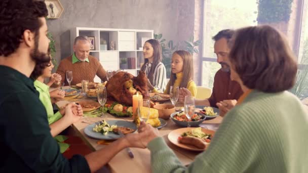 Веселая семья сидеть обеденный стол держаться за руки прошу взять столовые приборы — стоковое видео