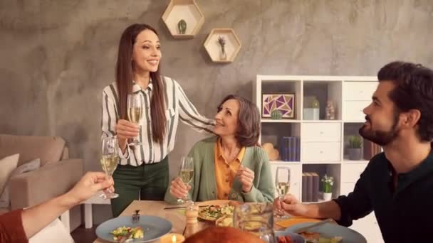 Повні сімейні люди сидять за столом мама тримає склянку кажуть тост конгреси — стокове відео