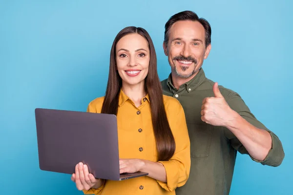 Fénykép barna hajú férj feleség pár hold laptop hogy hüvelykujj fel elszigetelt kék színű háttér — Stock Fotó