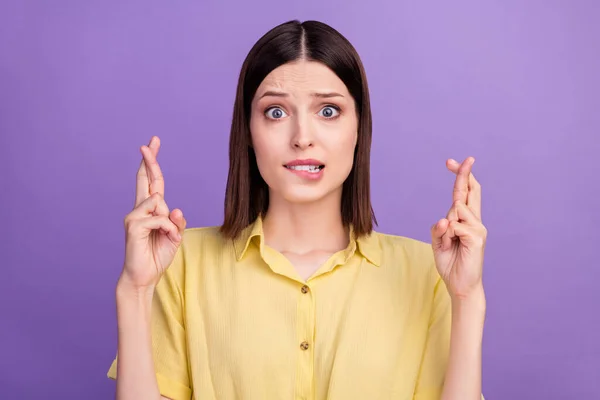 Foto van jong meisje beet lippen tanden angst gekruiste vingers pleiten wens geluk geïsoleerd over violette kleur achtergrond — Stockfoto